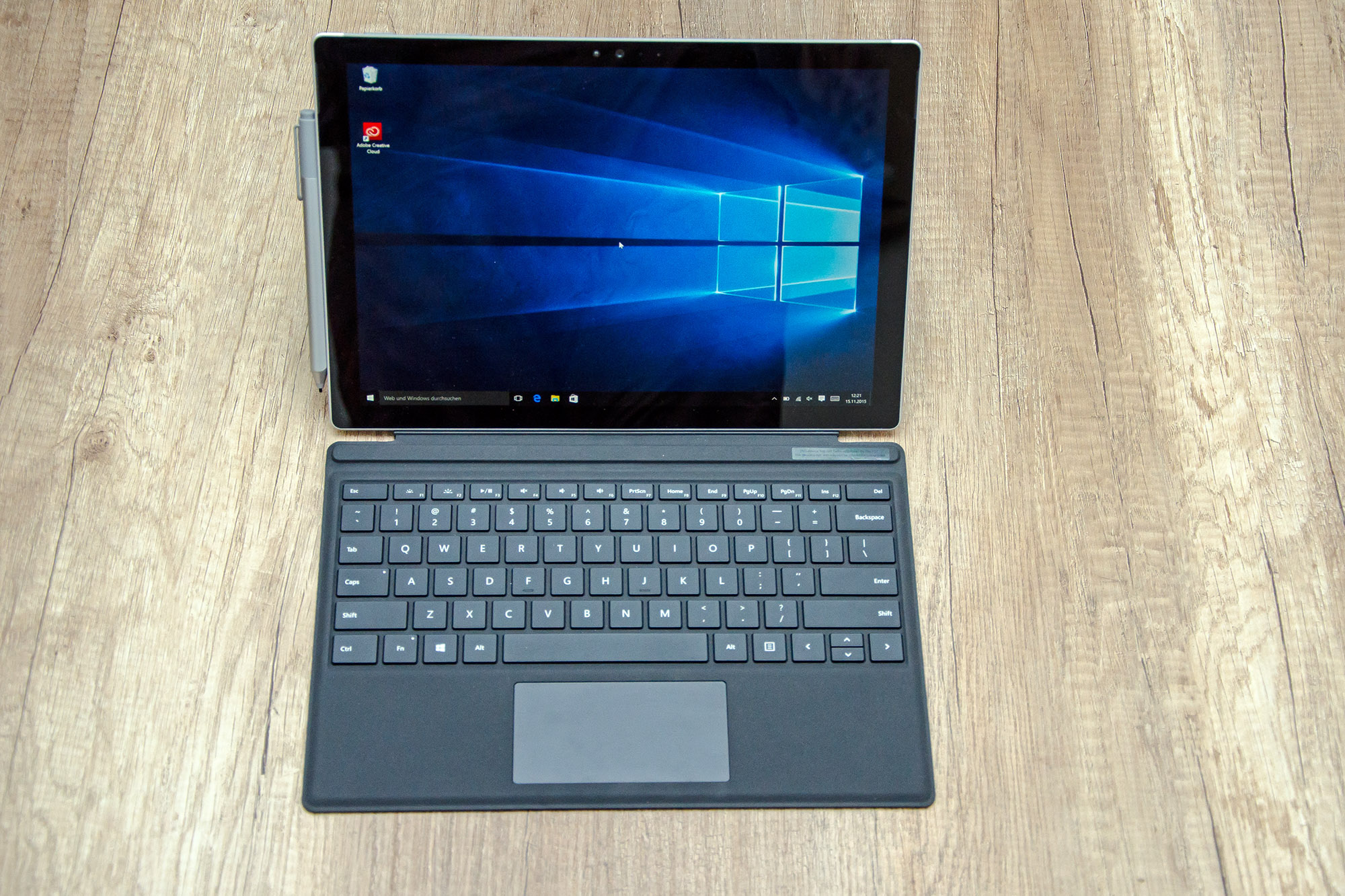 Microsoft Surface mit schwarzem Keyboard auf einem Holztisch mit Stylus